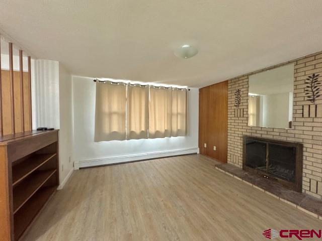 1221 First Street Alamosa, CO 81101 - Photo 5 of 40 a view of an empty room with a fireplace and a window