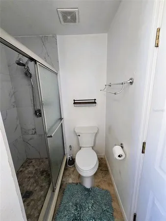 a bathroom with a toilet and a shower