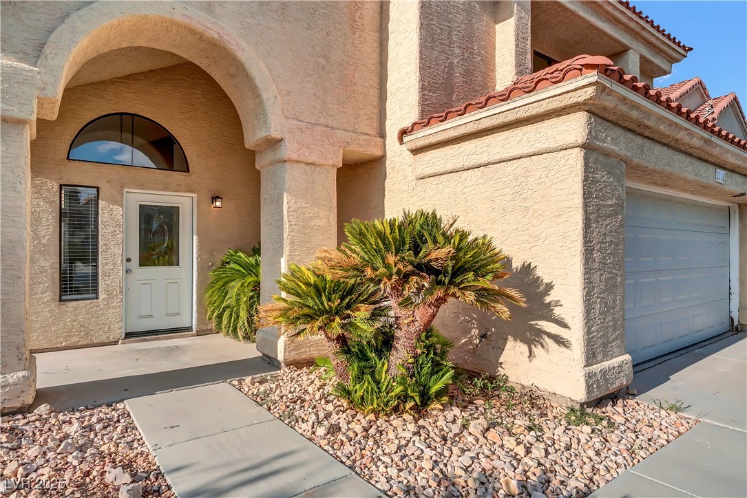 2716 Knightsbridge Road Henderson, NV 89074 - Photo 2 of 27 Property entrance with a tiled roof, stucco siding, and a garage