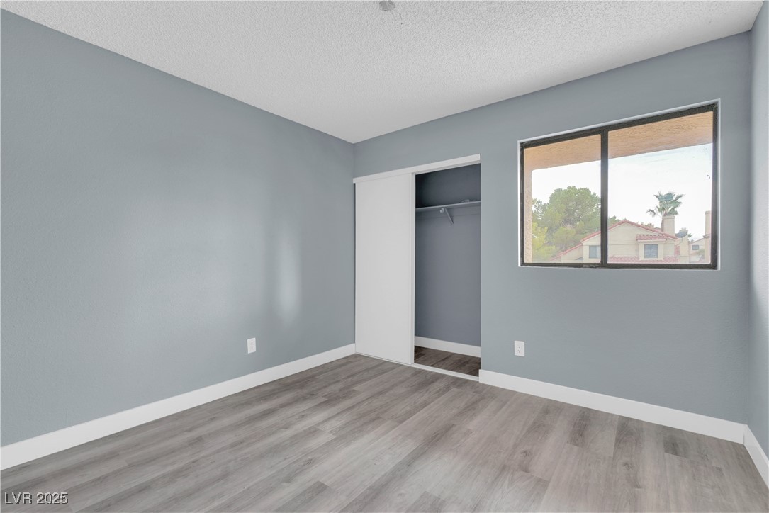 2716 Knightsbridge Road Henderson, NV 89074 - Photo 22 of 27 Unfurnished bedroom featuring wood finished floors, a closet, and a textured ceiling