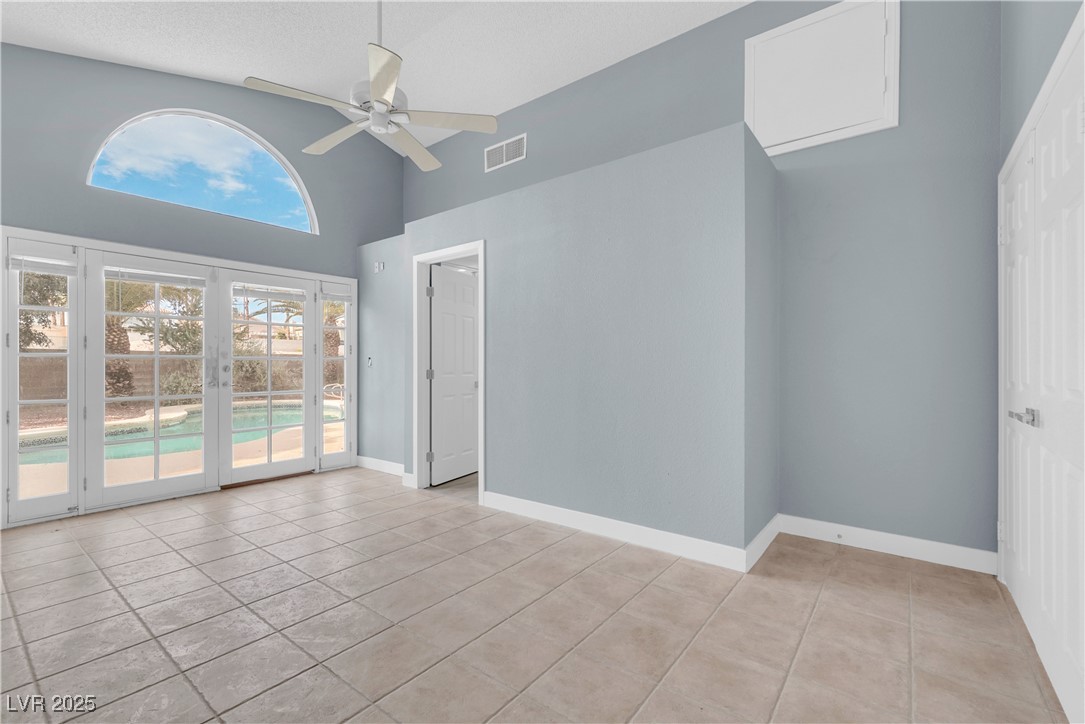 2716 Knightsbridge Road Henderson, NV 89074 - Photo 9 of 27 Unfurnished room featuring light tile patterned floors, a towering ceiling, and a ceiling fan