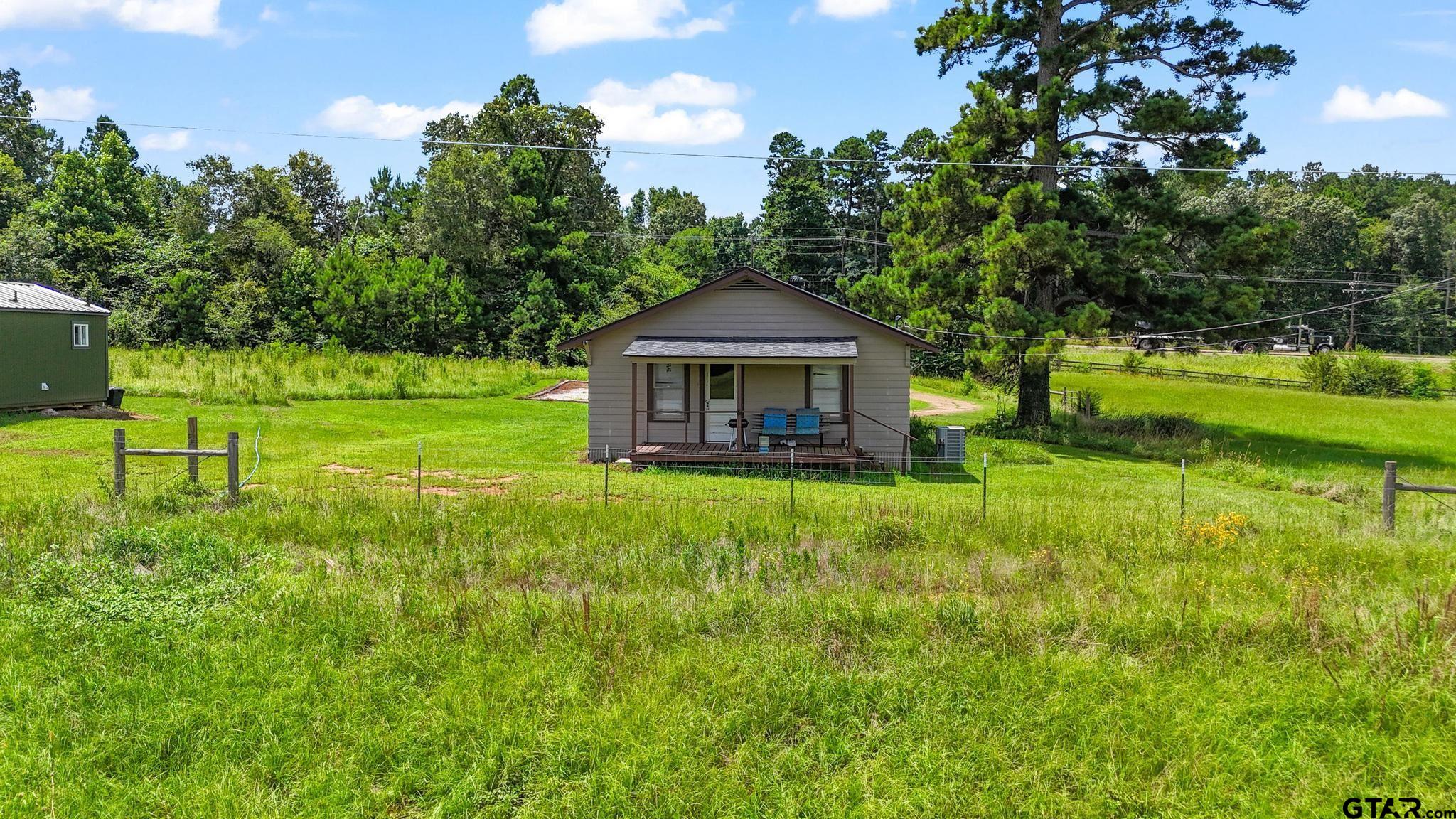 10864 State Highway 64 Overton, TX 75684 - Photo 14 of 32 a backyard of a house with lots of green space and fountain