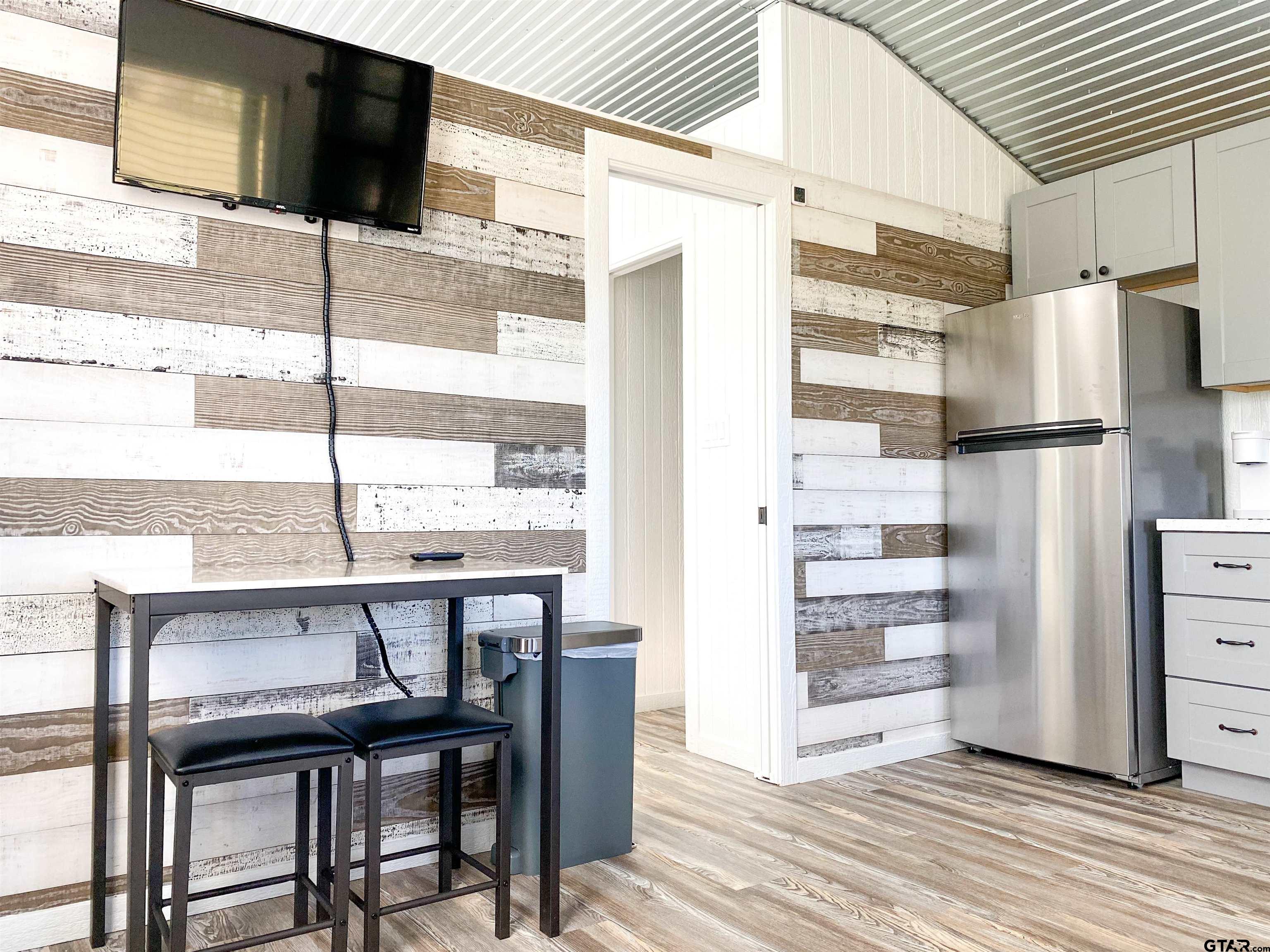 10864 State Highway 64 Overton, TX 75684 - Photo 19 of 32 a kitchen with stainless steel appliances kitchen island granite countertop a refrigerator and cabinets