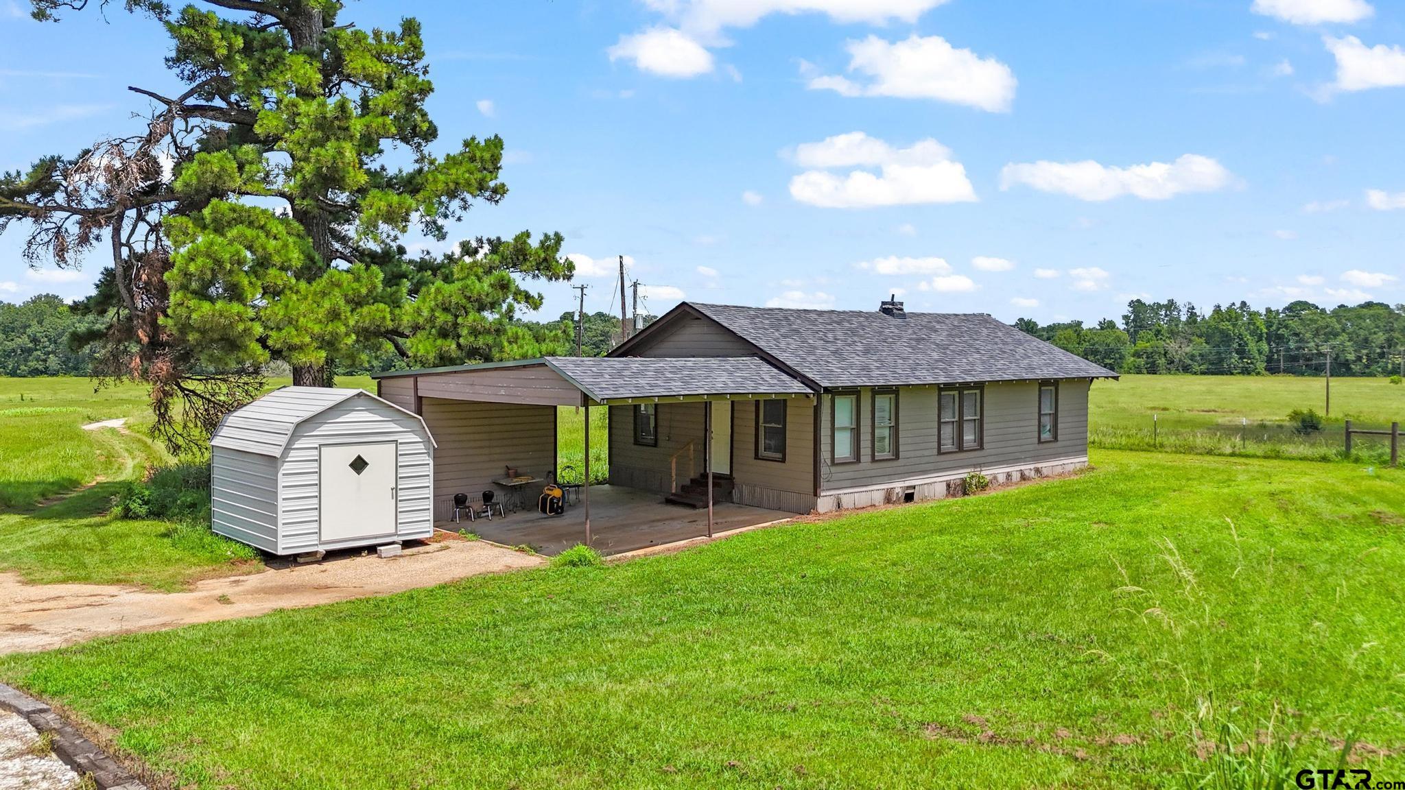 10864 State Highway 64 Overton, TX 75684 - Photo 2 of 32 a front view of a house with a garden and deck