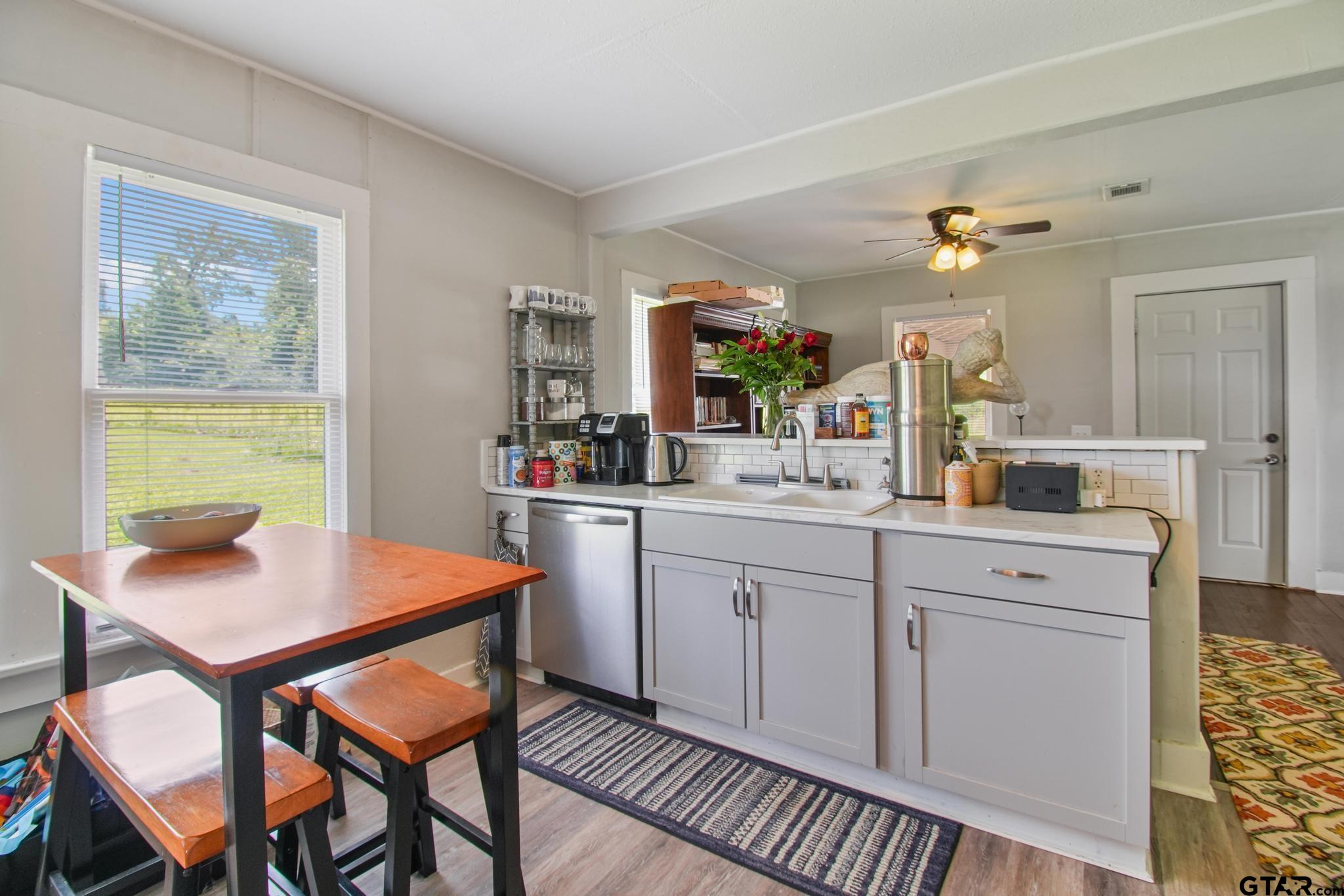 10864 State Highway 64 Overton, TX 75684 - Photo 5 of 32 a kitchen with a dining table chairs and white cabinets