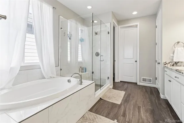 a bathroom with a granite countertop sink a mirror and a shower