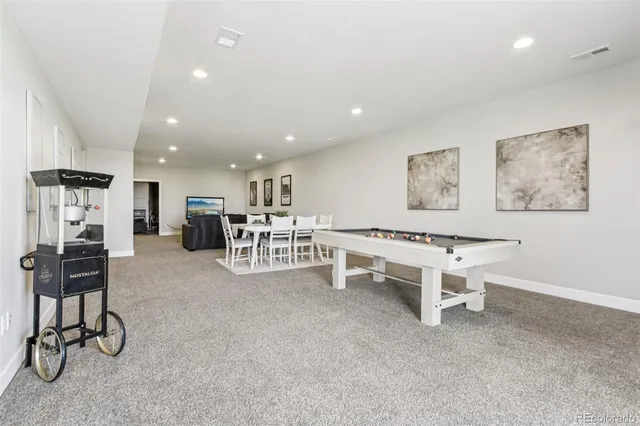 a living room with furniture a table and kitchen view