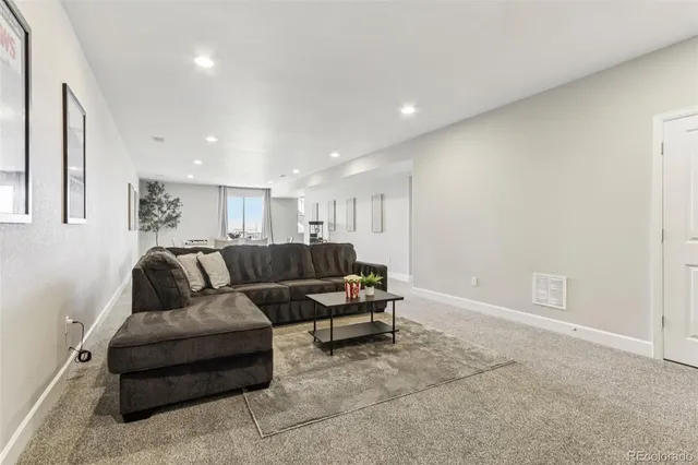 a living room with furniture and a view of kitchen