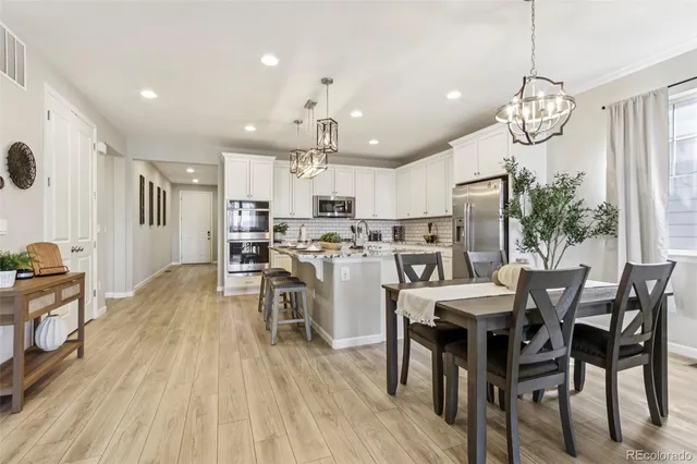a view of a dining room with furniture wooden floor and chandelier