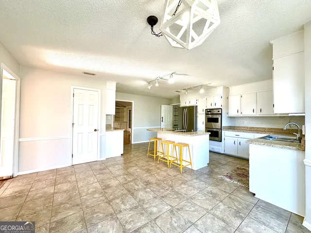 a large kitchen with kitchen island granite countertop lots of counter top space and stainless steel appliances