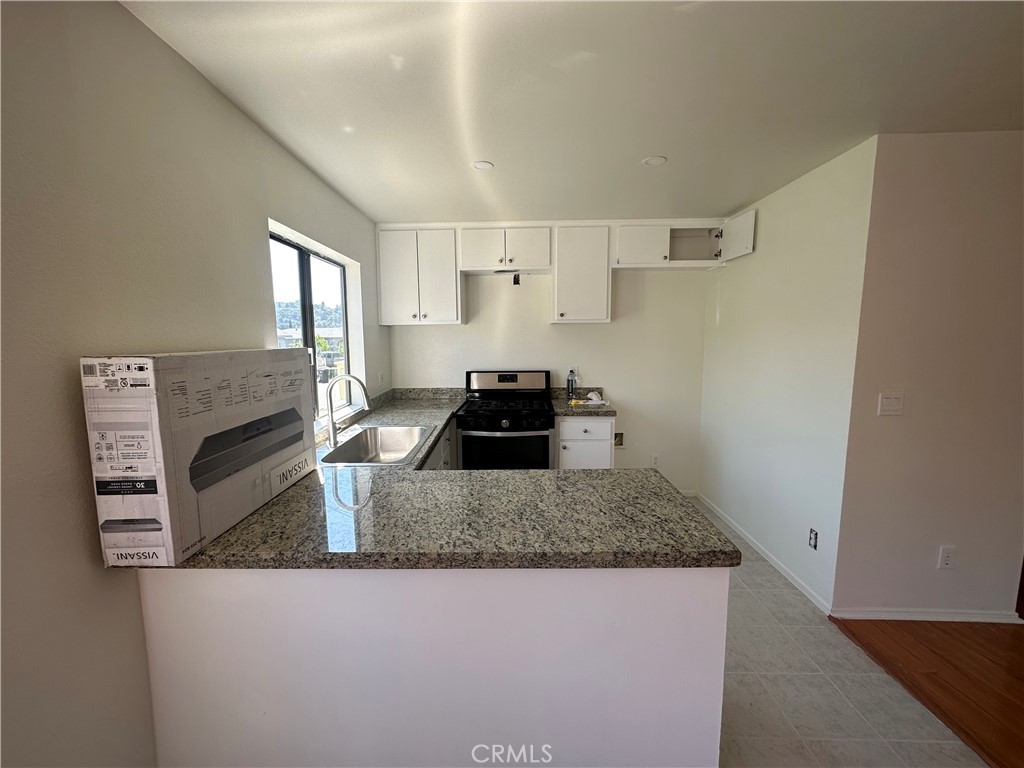 9961 Marcus Avenue, Unit 1 Tujunga, CA 91042 - Photo 2 of 16 a kitchen view with granite countertop a stove and a refrigerator