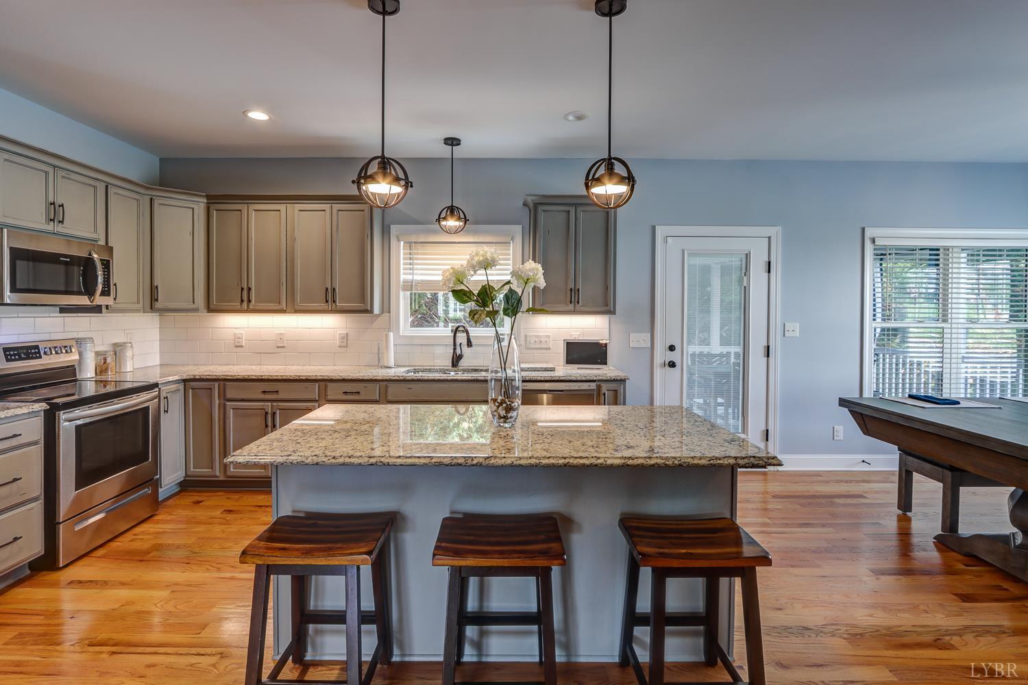 1013 Cobblestone Lane Forest, VA 24551 - Photo 16 of 49 a kitchen with stainless steel appliances granite countertop a stove a sink a oven a dining table and chairs with wooden floor