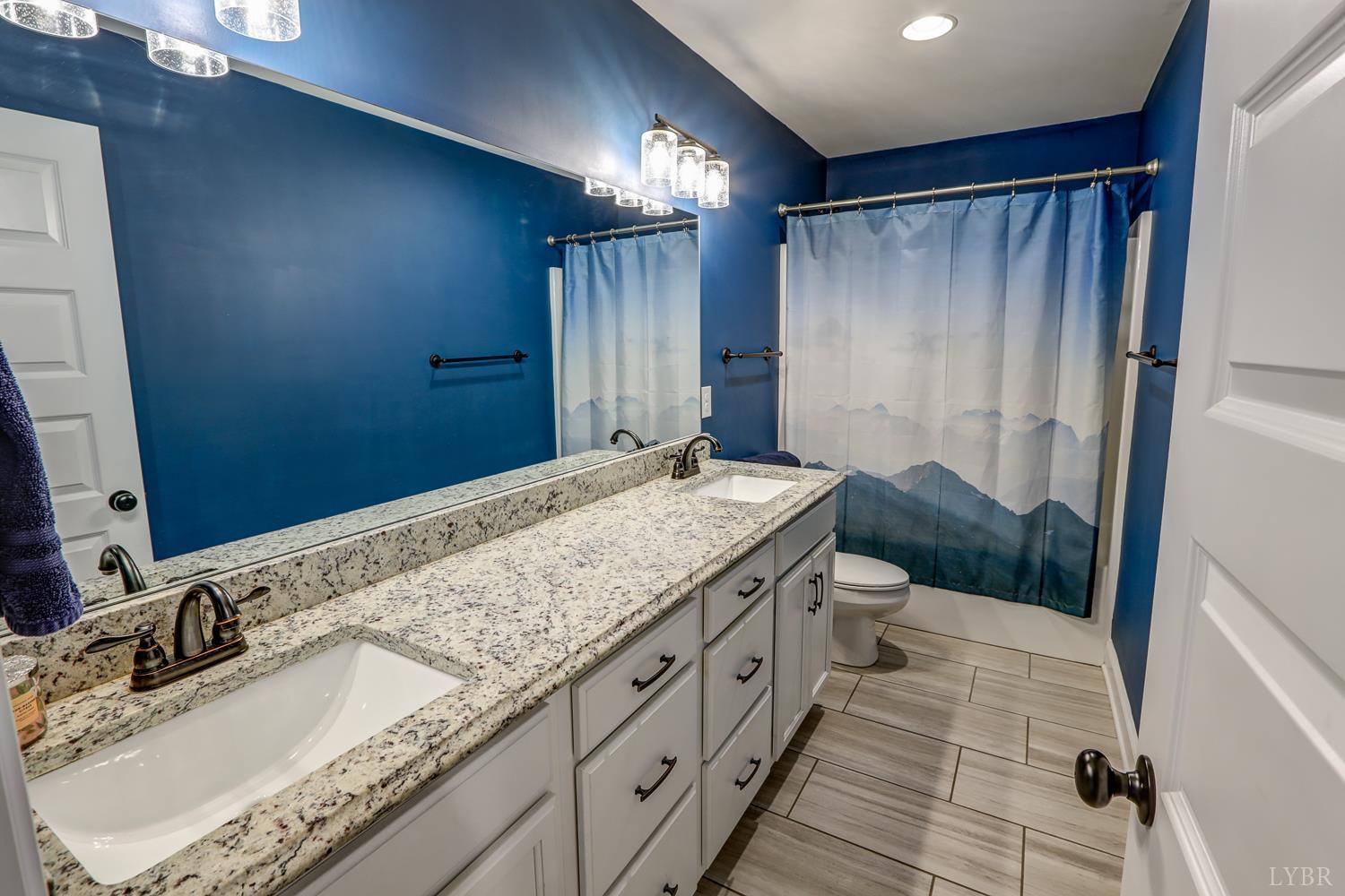 1013 Cobblestone Lane Forest, VA 24551 - Photo 27 of 49 a bathroom with a granite countertop sink a mirror and shower