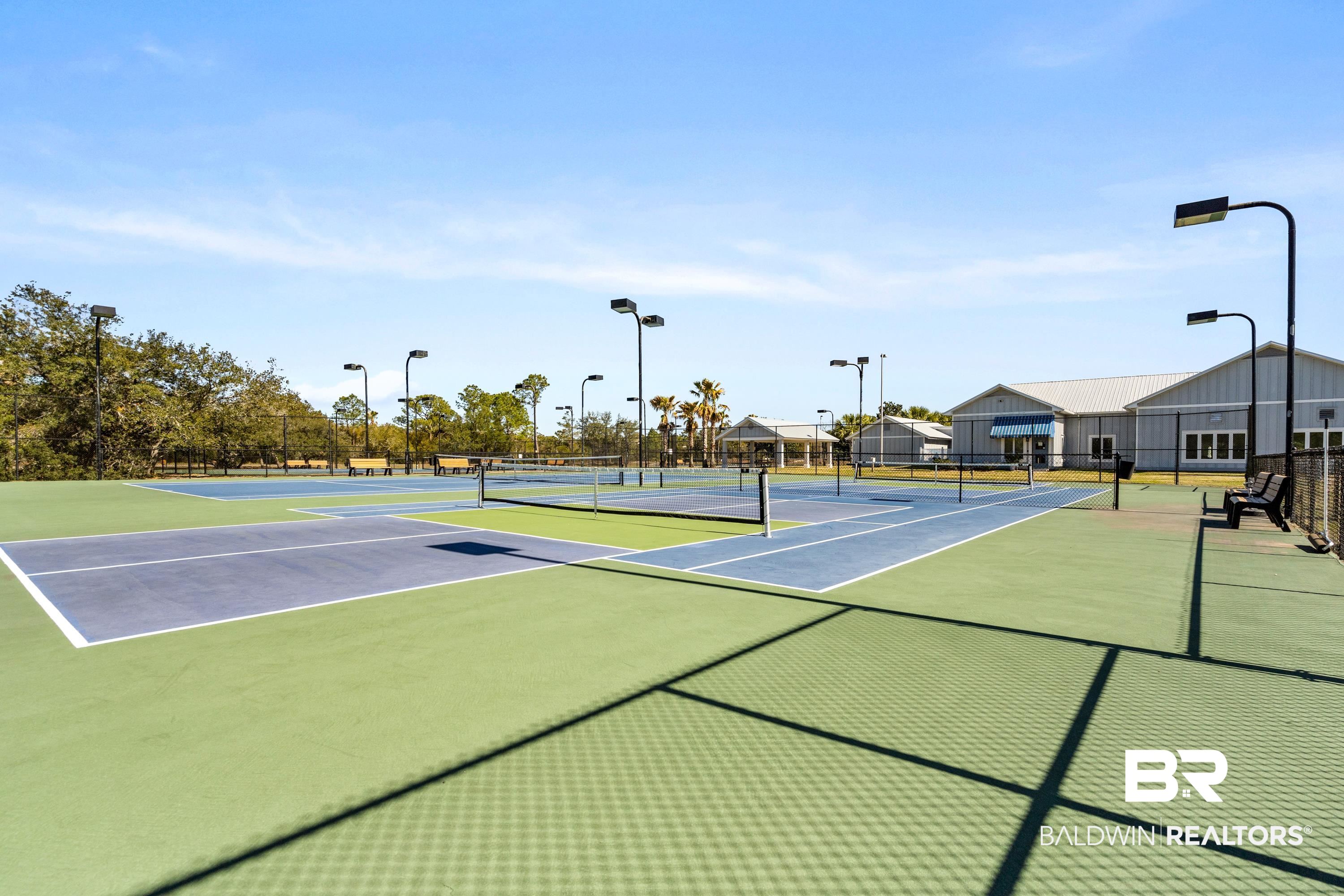 30194 River Road Orange Beach, AL 36561 - Photo 39 of 45 Multiple outdoor courts featuring blue and green playing surfaces, perimeter fencing, and overhead lighting fixtures