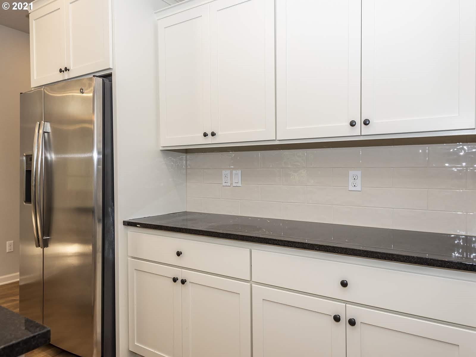 3736 South 42nd Place Ridgefield, WA 98642 - Photo 13 of 31 a kitchen with granite countertop white cabinets and a refrigerator