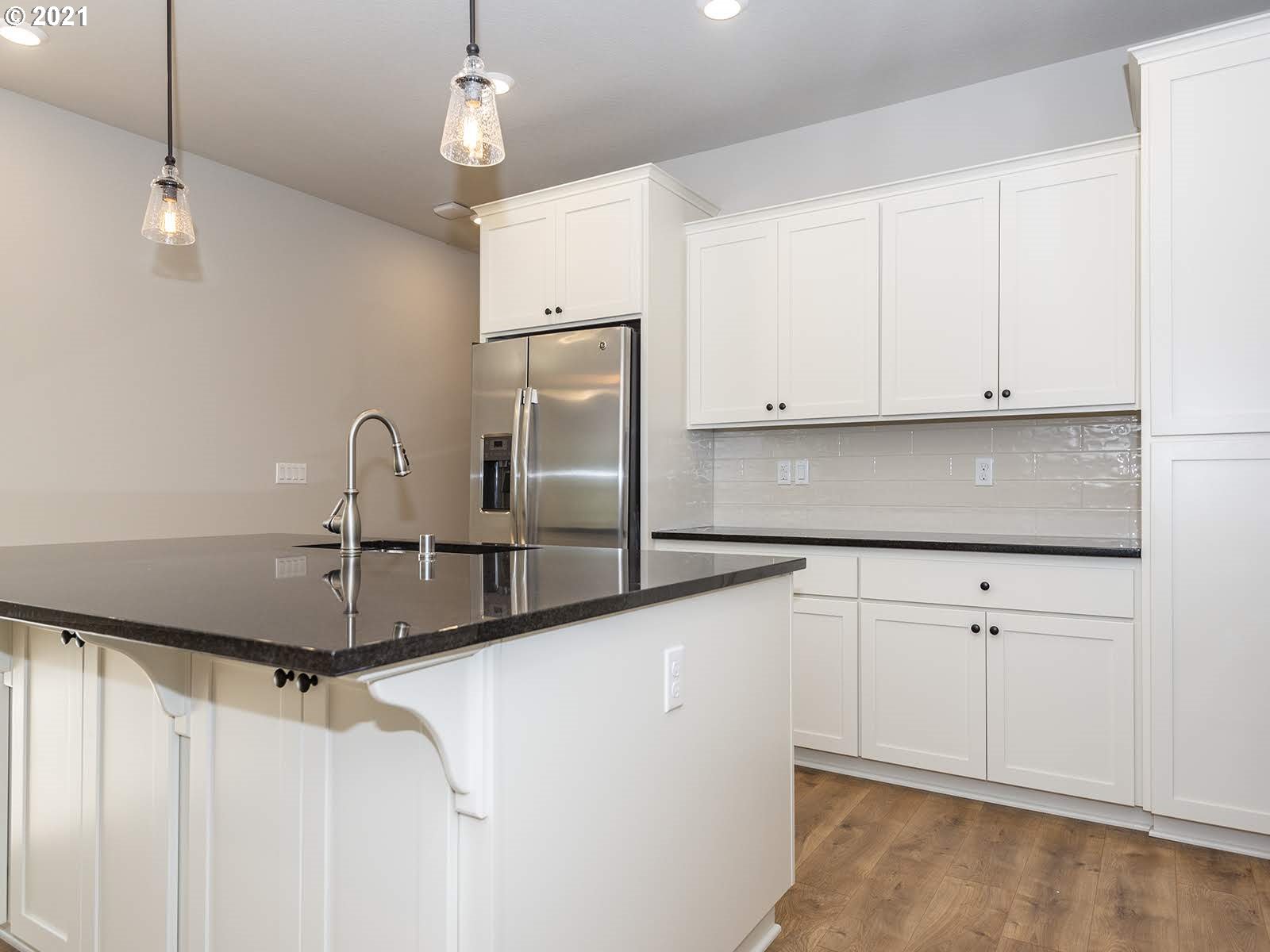 3736 South 42nd Place Ridgefield, WA 98642 - Photo 14 of 31 a kitchen with stainless steel appliances granite countertop a sink a stove and white cabinets