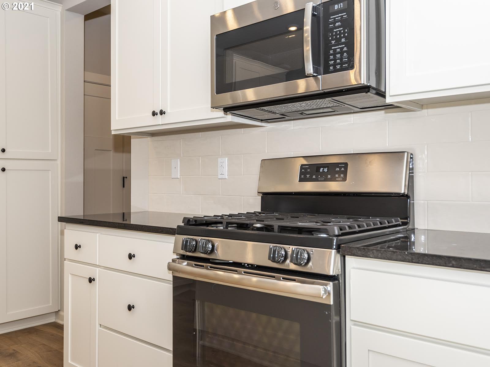 3736 South 42nd Place Ridgefield, WA 98642 - Photo 18 of 31 a kitchen with stainless steel appliances granite countertop white cabinets stove and microwave