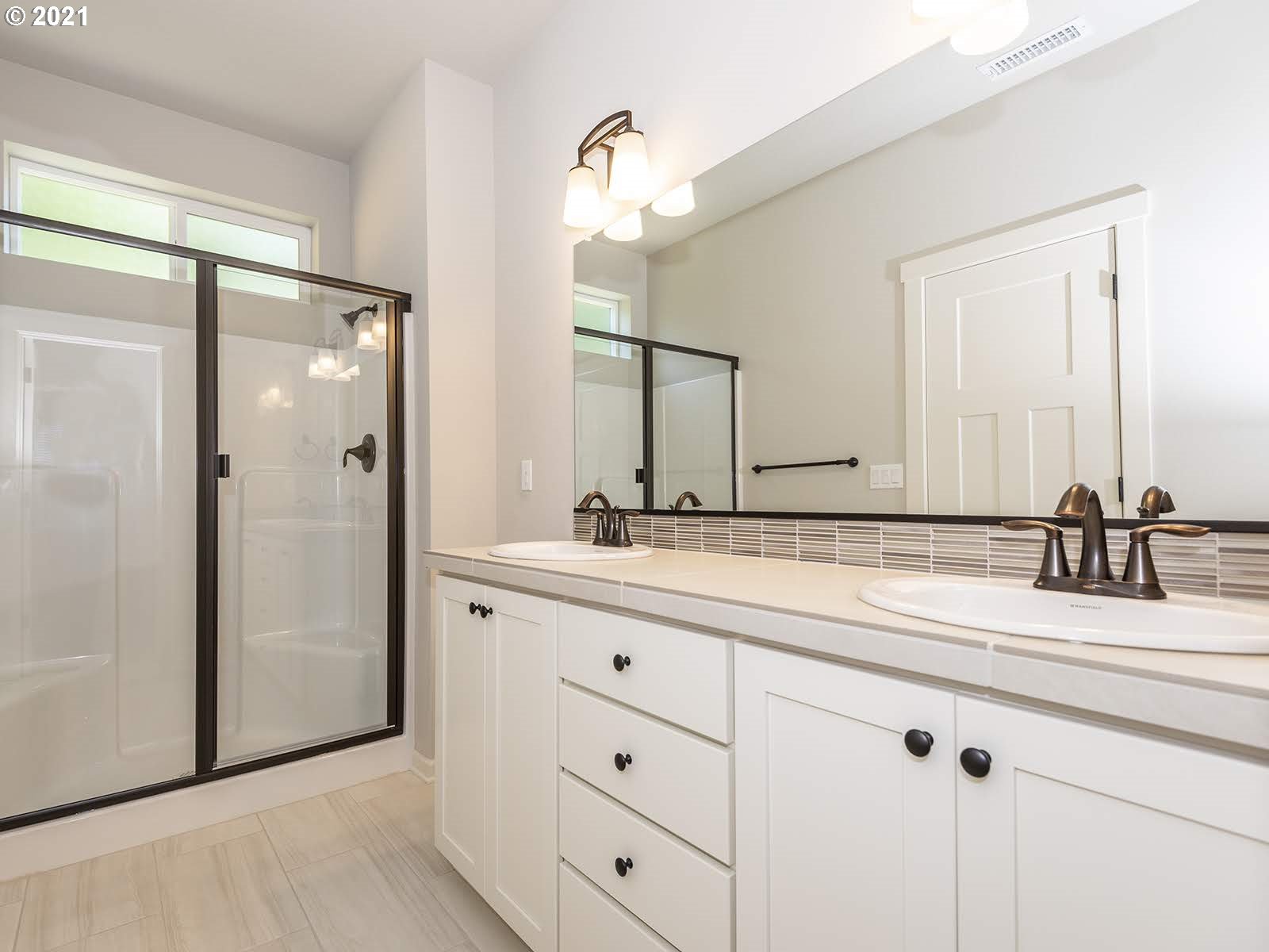 3736 South 42nd Place Ridgefield, WA 98642 - Photo 23 of 31 a bathroom with a double vanity sink mirror and shower