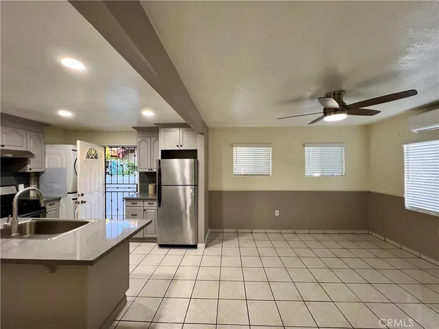 a kitchen with a sink a refrigerator and cabinets