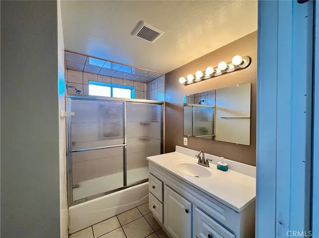 a bathroom with a shower sink and mirror