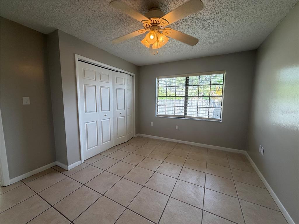 1405 Crystal Court, Unit C Tavares, FL 32778 - Photo 3 of 15 an empty room with chandelier fan and windows