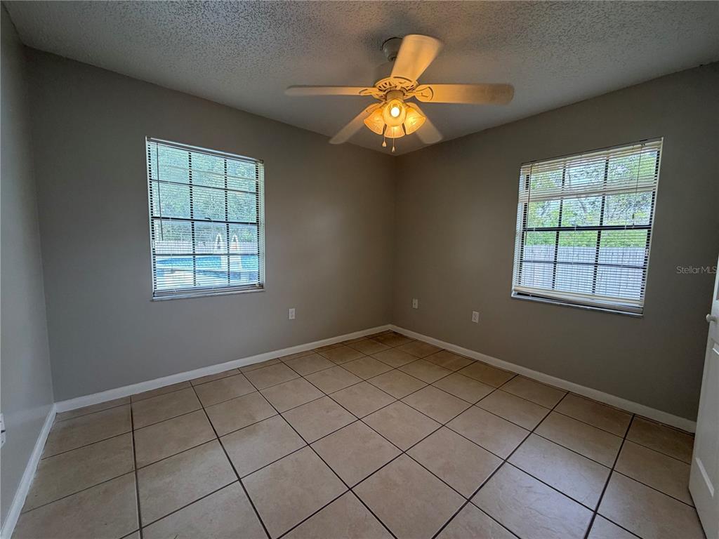 1405 Crystal Court, Unit C Tavares, FL 32778 - Photo 7 of 15 an empty room with windows and chandelier fan