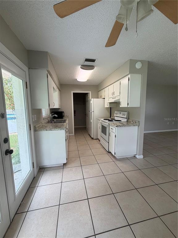 1405 Crystal Court, Unit C Tavares, FL 32778 - Photo 9 of 15 a kitchen with a stove a sink dishwasher and a refrigerator