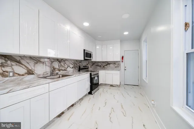 a kitchen with granite countertop white cabinets and white appliances