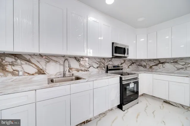 a kitchen with stainless steel appliances granite countertop a sink and a stove top oven