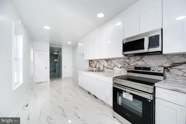 a kitchen with stainless steel appliances granite countertop a stove a microwave and a sink