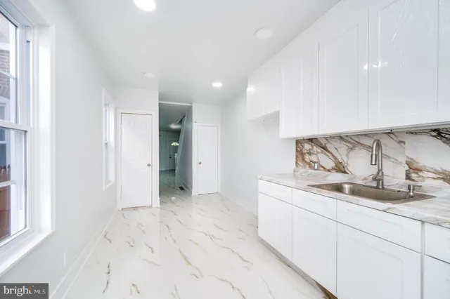 a kitchen with granite countertop a sink and a stove