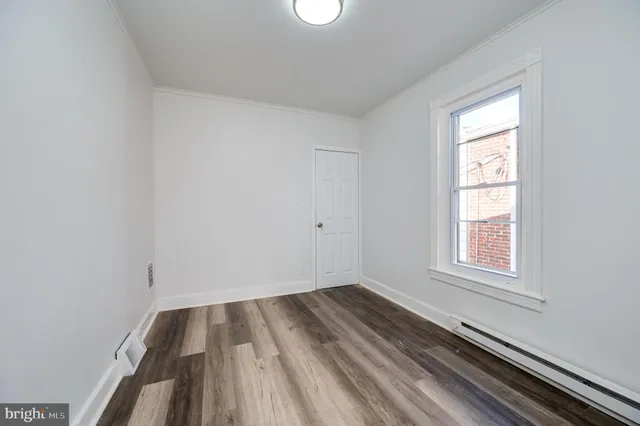 a view of a room with wooden floor and windows