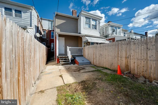 a view of a house with a small yard and wooden fence