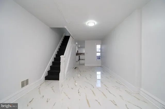 a view of entryway and hall with wooden floor