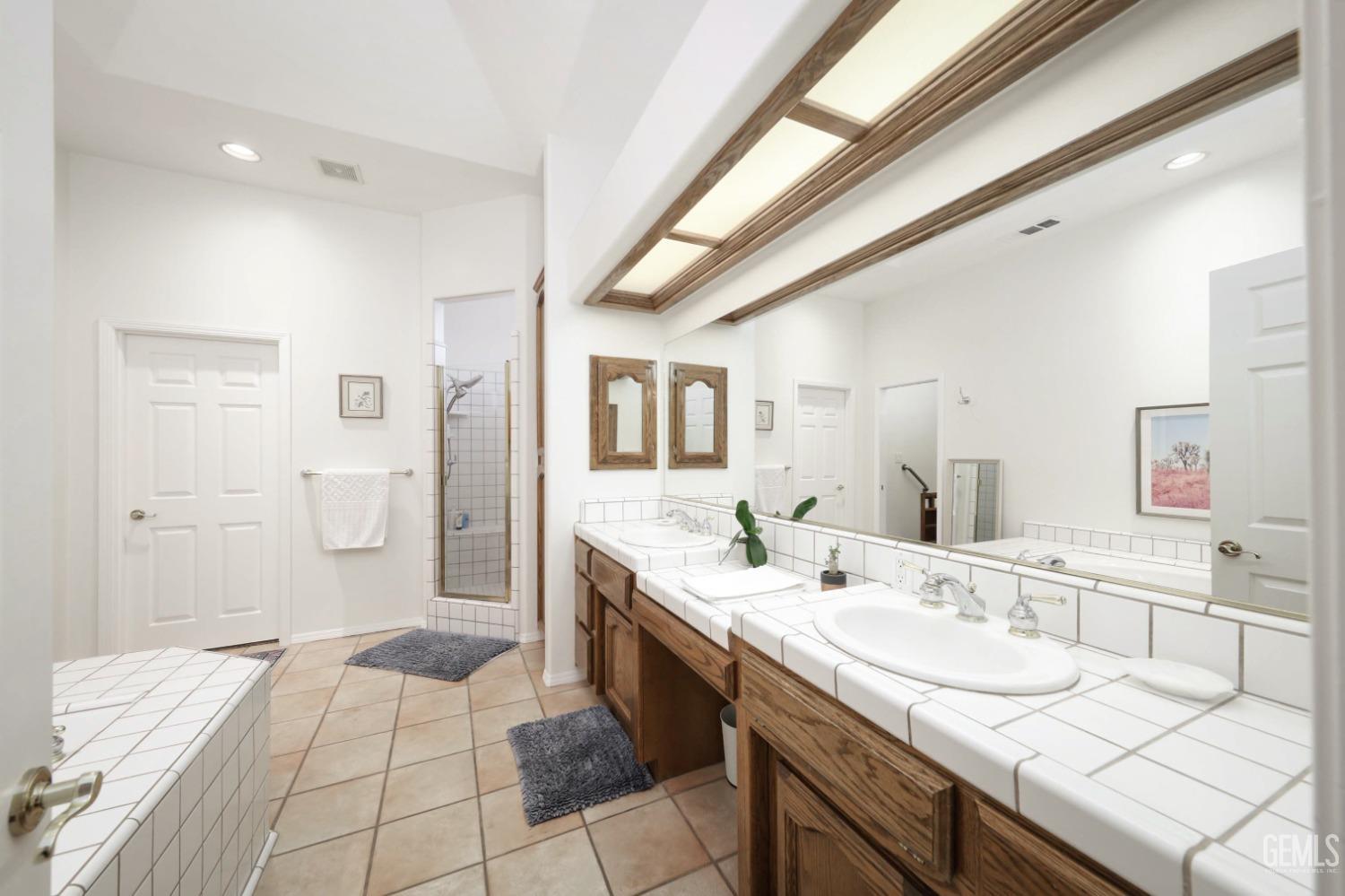 Undisclosed Address Bakersfield, CA 93312 - Photo 13 of 39 a spacious bathroom with a sink a mirror and a shower