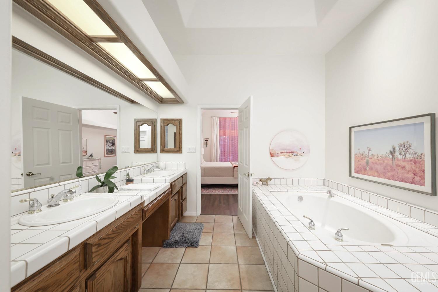 Undisclosed Address Bakersfield, CA 93312 - Photo 14 of 39 a spacious bathroom with a bathtub a sink and a mirror