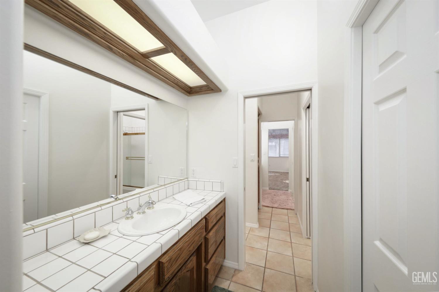 Undisclosed Address Bakersfield, CA 93312 - Photo 18 of 39 a bathroom with a double vanity sink and a mirror