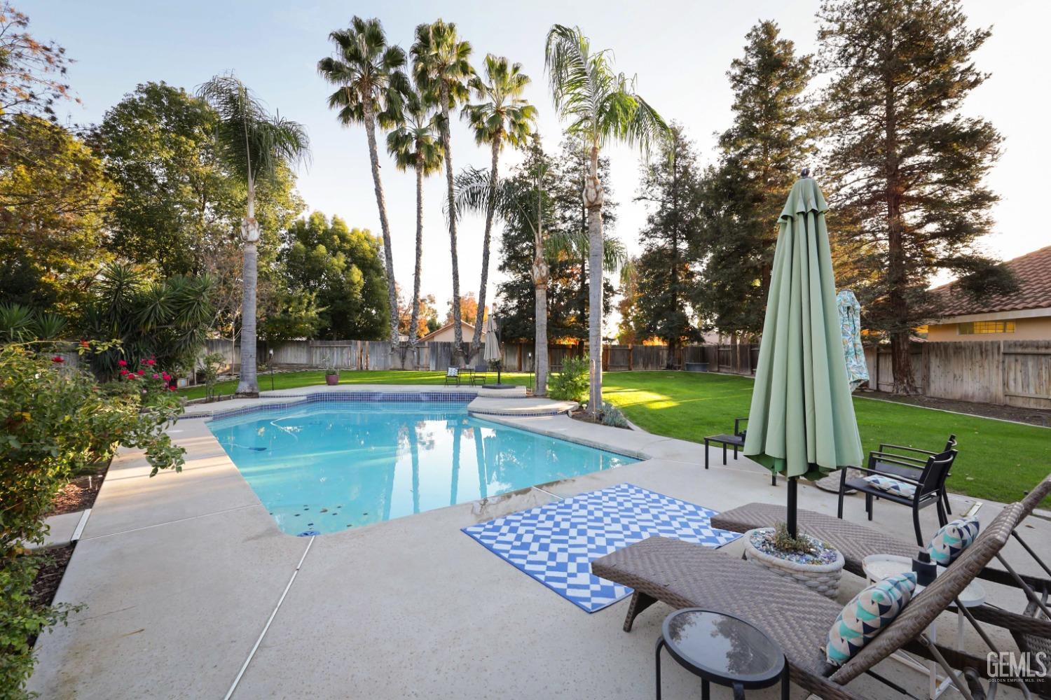 Undisclosed Address Bakersfield, CA 93312 - Photo 27 of 39 a view of a swimming pool with lawn chairs and a fire pit