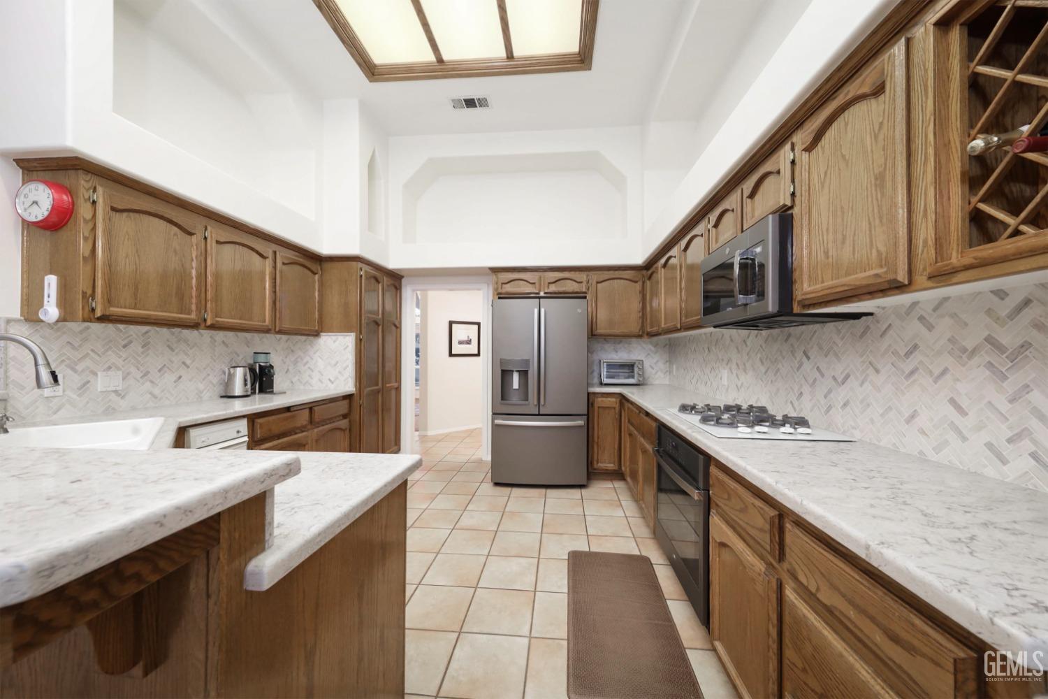 Undisclosed Address Bakersfield, CA 93312 - Photo 6 of 39 a kitchen with a sink stove and cabinets