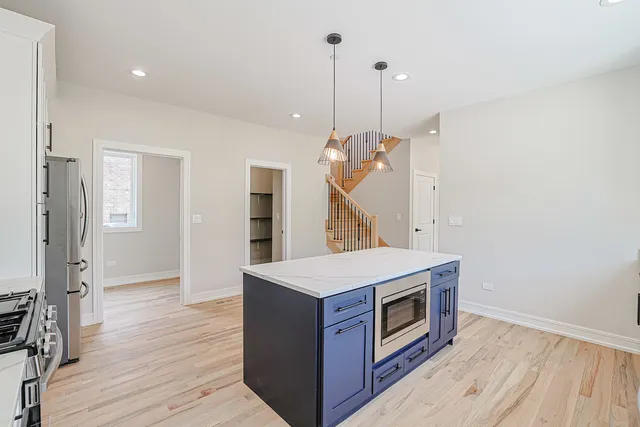 a kitchen with a stove and a wooden floor