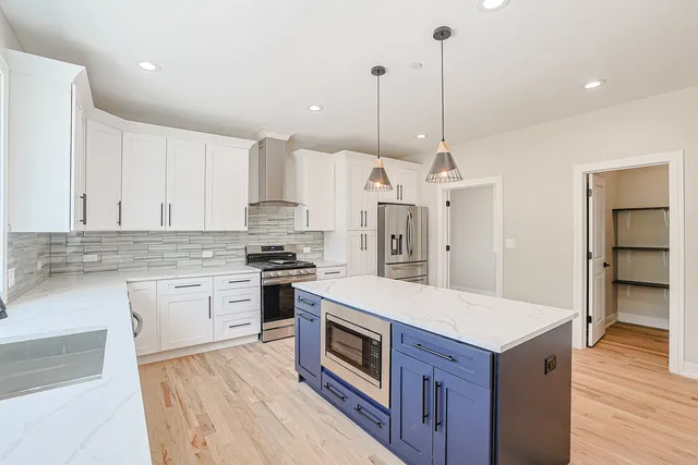 a kitchen with a stove kitchen island and stainless steel appliances