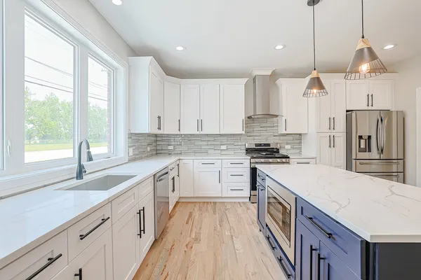 a kitchen with stainless steel appliances granite countertop a sink stove and refrigerator