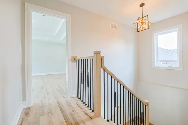 a view of a hallway with wooden floor and stairs