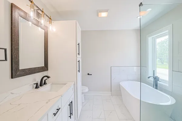 a bathroom with a sink a toilet and shower