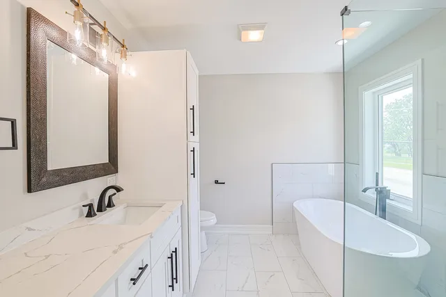 a bathroom with a sink a toilet and shower