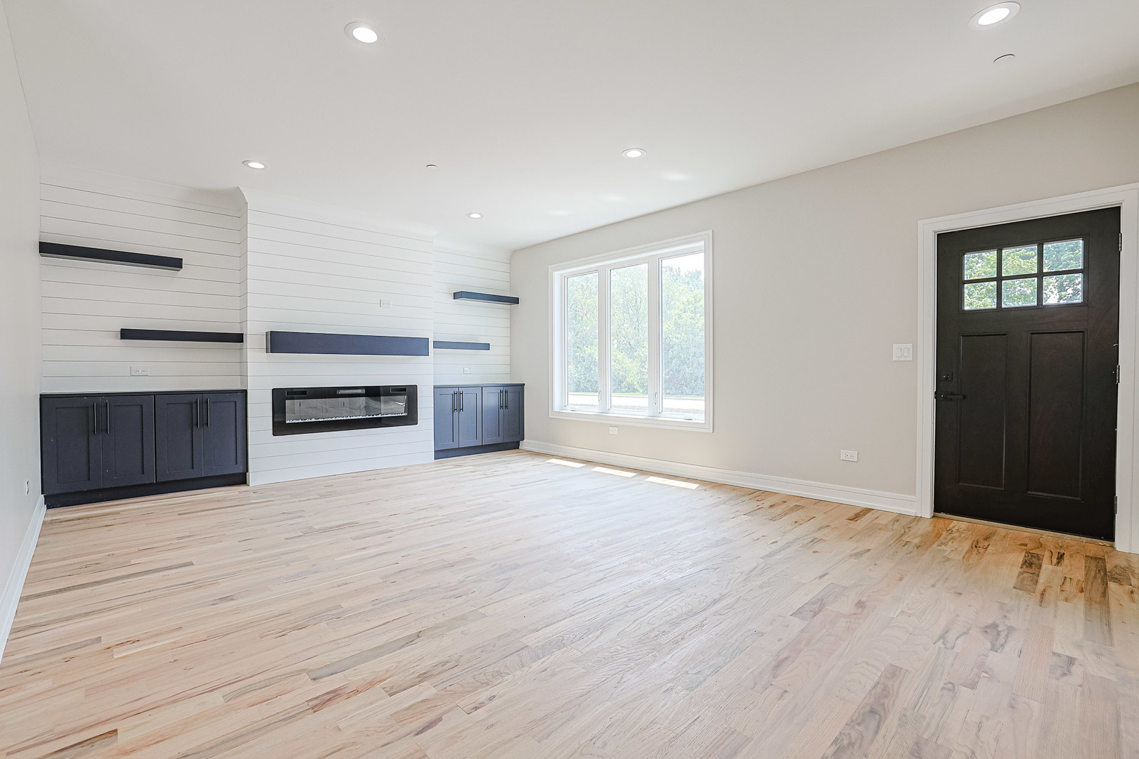 7948 West 74th Avenue Bridgeview, IL 60455 - Photo 8 of 39 a view of an empty room with a window and wooden floor