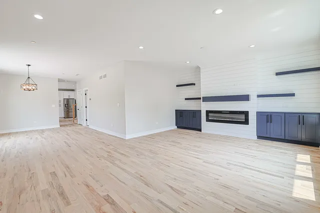 a view of a kitchen with wooden floor and electronic appliances