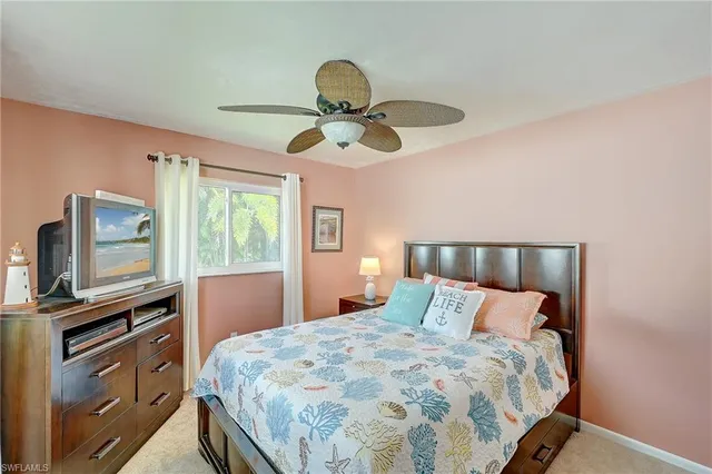 a bedroom with a bed and a flat tv screen on dresser