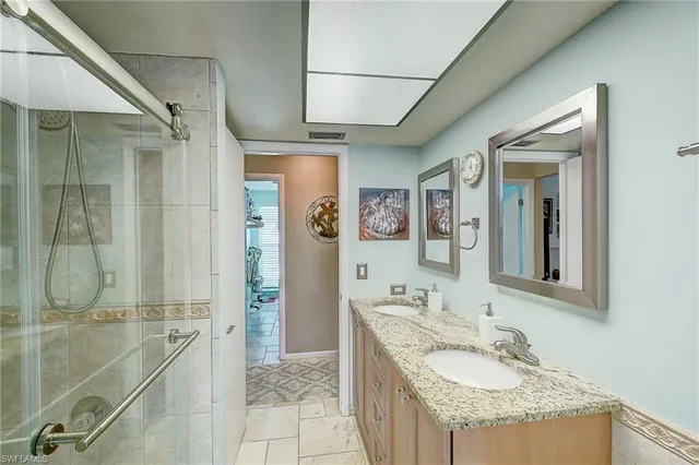 a bathroom with a granite countertop sink a mirror and a shower