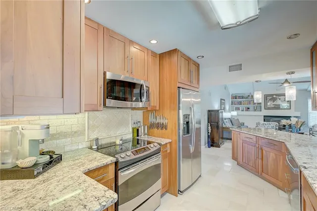 a kitchen with granite countertop a sink stove and refrigerator